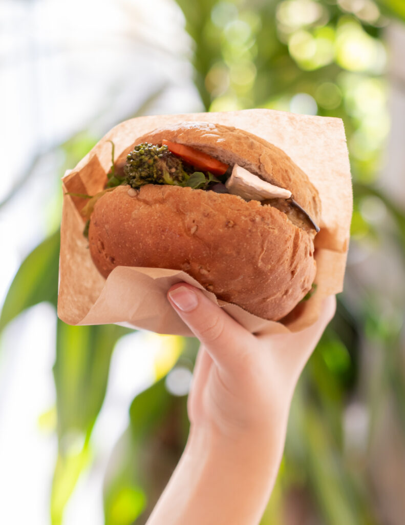Veganistisch broodje met Fervena gefermenteerde kaas in de hand, een smakelijk en gezond alternatief!