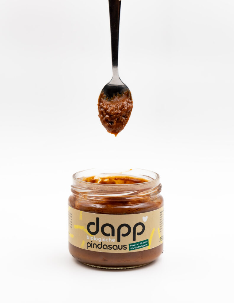 Een lepel in een pot Dapp pindasaus.
